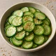 Sunomono uborkával, vékonyra szeletelt uborka édes-savanyú páclében szezámmaggal tálalva
