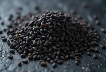 fekete hántolatlan szezámmag szórtan fa felületen és kis tálban