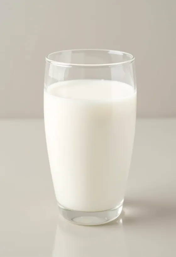 Egy pohár és egy üveg friss tej egy világos konyhapulton, állati elemek nélkül
