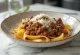 Wild boar ragu with pappardelle served in a rustic plate.