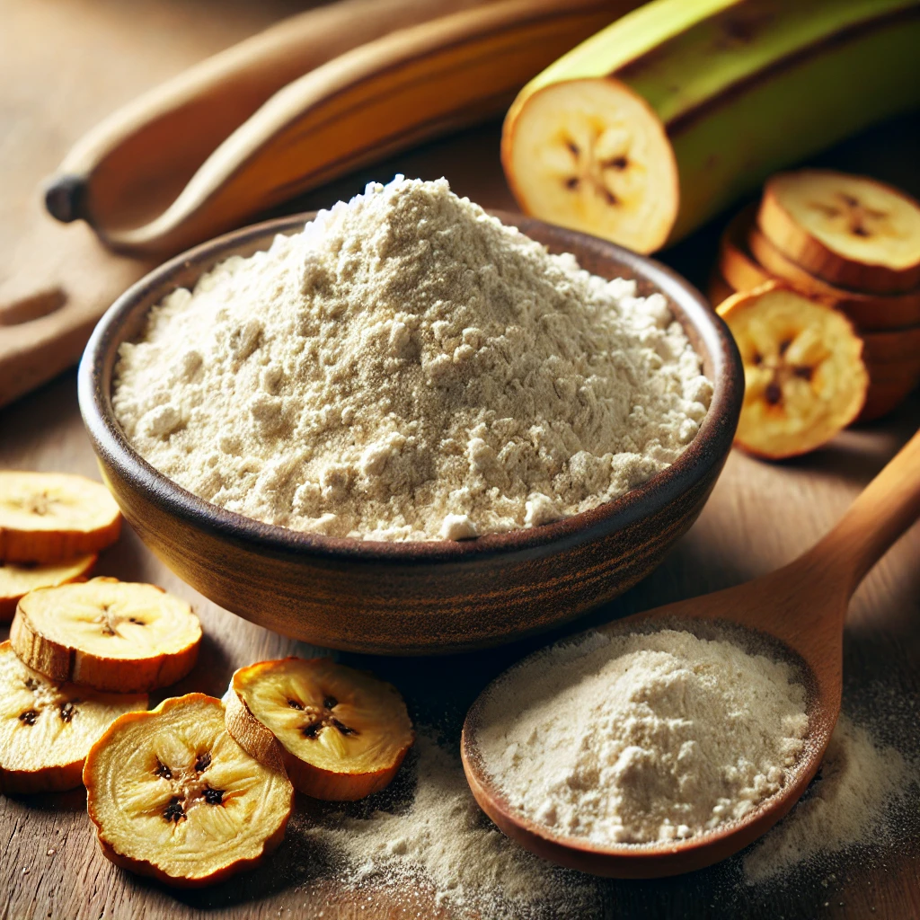 A képen világos színű plantain liszt látható kerámiatálban, fakanálban és mellette zöld plantain és szárított szeletek.