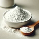 Fehér sütőpor kis tálkában és fa mérőkanálon, világos háttérrel