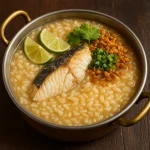Arroz Caldo halas változatban, sült halfilével, zöldhagymával és ropogós fokhagymával tálalva