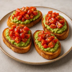 Bruschetta avokádóval és paradicsommal, pirított bagett szeleteken tálalva